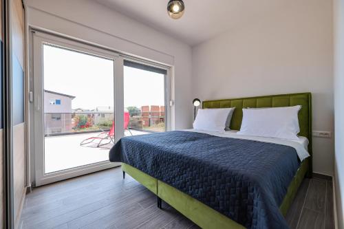 ein Schlafzimmer mit einem Bett und einem großen Fenster in der Unterkunft Residence Bella Vista in Bibinje
