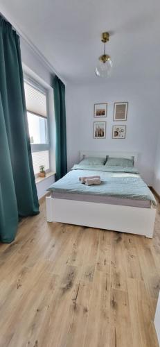 a bedroom with a bed and a wooden floor at Apartament 6 in Gołdap