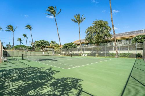 a tennis court with palm trees in the background at Kihei Bay Surf 245 in Kihei