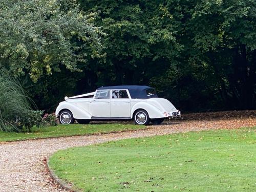 a white car parked on the side of a road at The Secret Cottage & Hideaway Caravan in Cudham