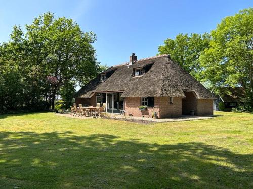 an old house with a grass roof on a field at Unieke Twentse boerderij - 4 bedrooms & huge private garden in Den Ham