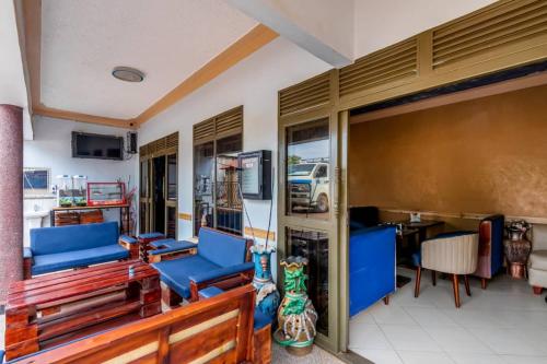 a living room with blue chairs and a table at Haber Motel Enterprise Ltd in Entebbe