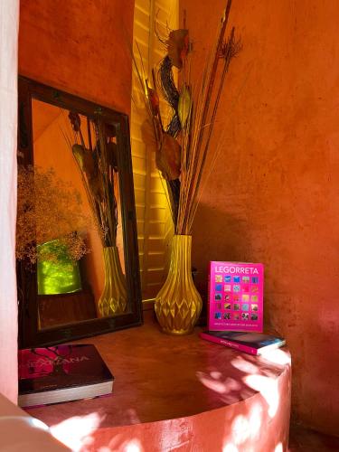 a table with two vases and a clock and a mirror at CASA CHAKÁ BOUTIQUE in Mérida