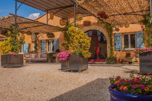 a patio with flowers in pots in front of a building at Le Mas des Sagnes in Collias