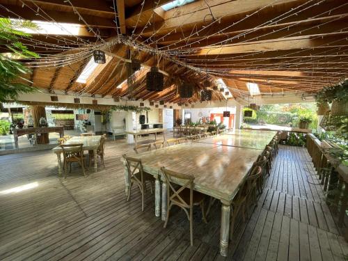 une grande terrasse en bois avec des tables et des chaises dans l'établissement Hotel Casa Madero, à Envigado