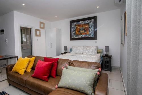 a living room with a brown couch with colorful pillows at Ghana luxury Apartments in Accra
