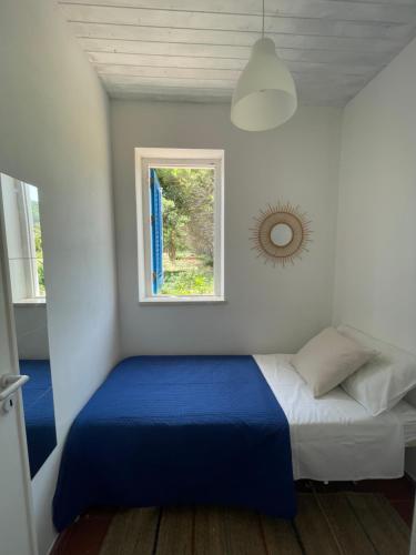 a bedroom with a blue and white bed and a window at Villa Paso in Ustica