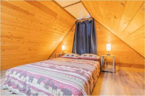 um quarto com uma cama num chalé de madeira em A Cabin You Won't Want to Leave em Fairbanks