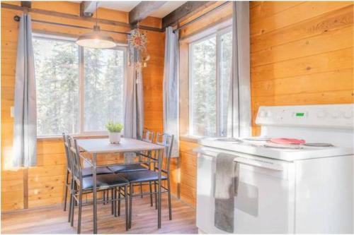 uma cozinha com uma mesa, uma mesa e um fogão em A Cabin You Won't Want to Leave em Fairbanks