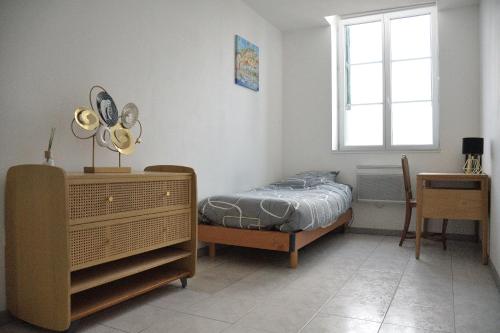 ein Schlafzimmer mit einem Bett, einer Kommode und einem Fenster in der Unterkunft La Domus Lemaitre - Parking - Wifi TV - autoroute in Lieu-Saint-Amand