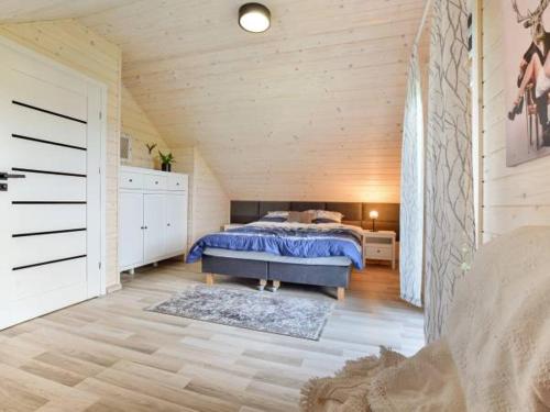 ein Schlafzimmer mit einem Bett und einer Holzdecke in der Unterkunft Domek Leniuchowo in Rabka-Zdrój