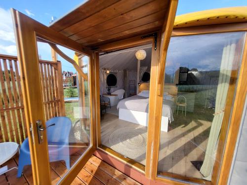 a room with a view of a bedroom through a glass door at Izera Glamping Adults - Luksusowe jurty&spa (adults only) in Gajowka
