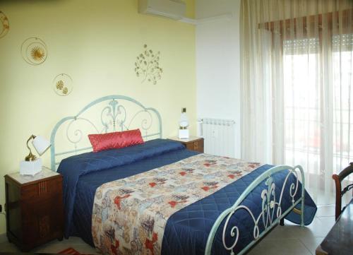 una camera da letto con un letto blu con un cuscino rosso di La Dimora di Livia a Lido di Ostia