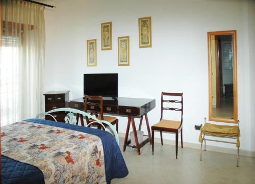 una camera da letto con scrivania, letto e tavolo di La Dimora di Livia a Lido di Ostia