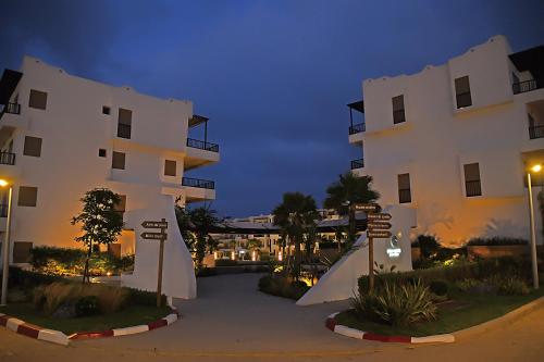 a large white building with street signs in front of it at AKS Home appart 1 - CABONEGRO in Cabo Negro