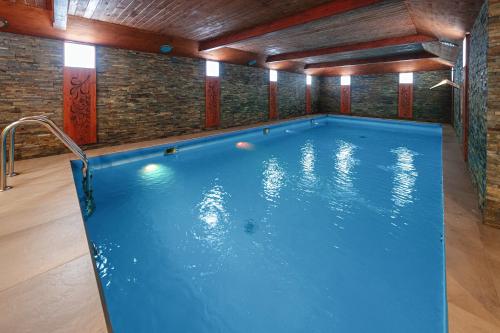 a large swimming pool in a room with a brick wall at Dom Wczasowy Jędrol in Poronin
