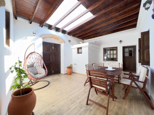 een woonkamer met een houten tafel en stoelen bij Villa AleNi Lindos in Lindos