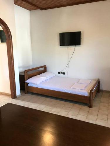 a bedroom with a bed and a tv on the wall at Sounio , Garden house in Sounio