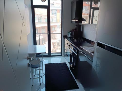 een kleine keuken met een wastafel en een raam bij BAOF residence in Istanbul