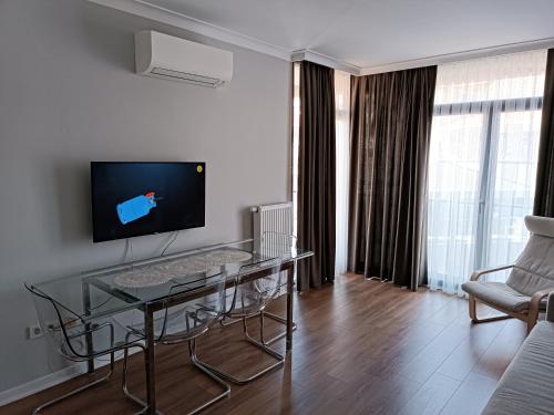 een woonkamer met een glazen tafel en een televisie bij BAOF residence in Istanbul
