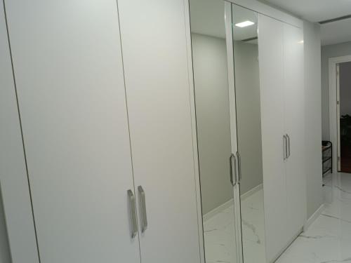 een witte kledingkast met glazen deuren in een kamer bij BAOF residence in Istanbul