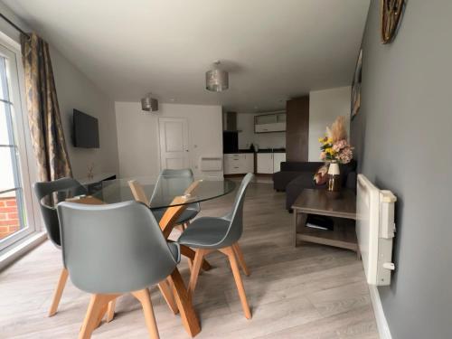 a dining room and living room with a table and chairs at Luxury Apartments - Wallis Square, Farnborough in Farnborough