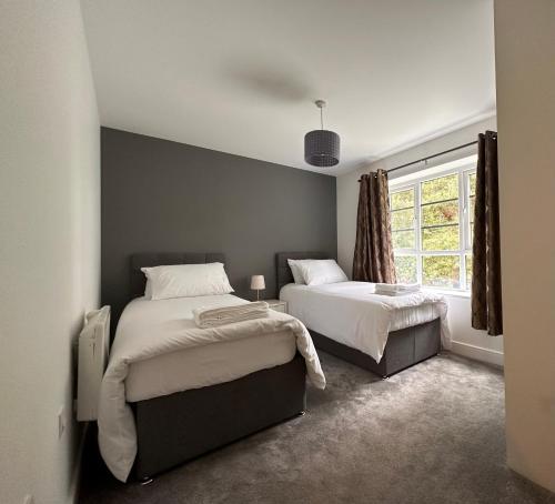 a bedroom with two beds and a window at Luxury Apartments - Wallis Square, Farnborough in Farnborough
