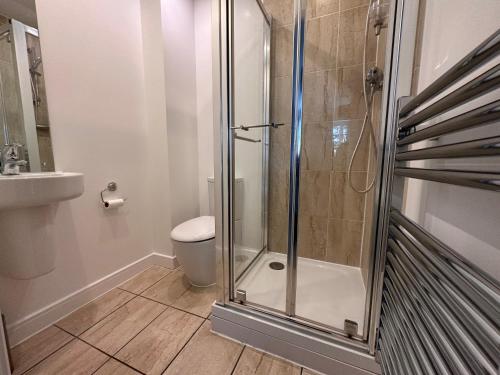 uma casa de banho com um chuveiro e um WC. em Luxury Apartments - Wallis Square, Farnborough em Farnborough