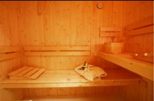 a wooden sauna with a cow laying on the floor at Spring Gardens Retreat And Spa Private hottub,Sauna,Massage in Great Malvern