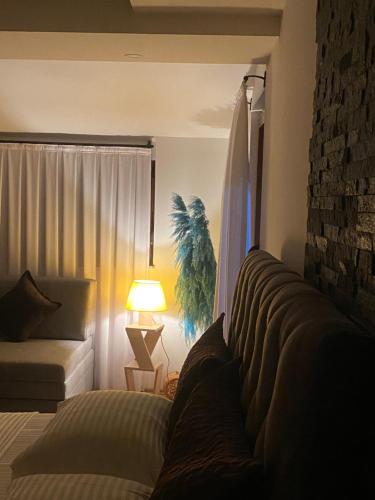 a bedroom with a couch and a lamp and a window at Zani Boutique Hotel in Prizren