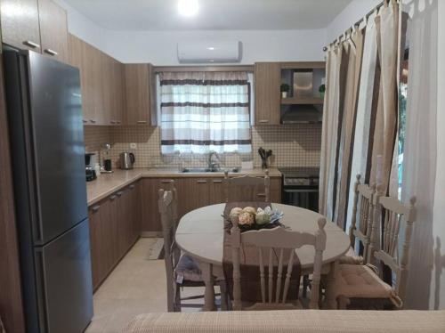 a kitchen with a table with chairs and a refrigerator at Κάμπος in Rizá