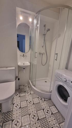 a bathroom with a shower sink and a washing machine at Mieszkanie Grunwaldzka in Olsztyn