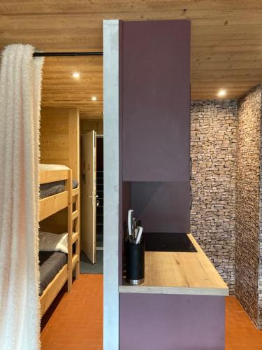 une chambre avec des lits superposés et une chambre avec un mur dans l'établissement Cœur de montagne, à Châtel