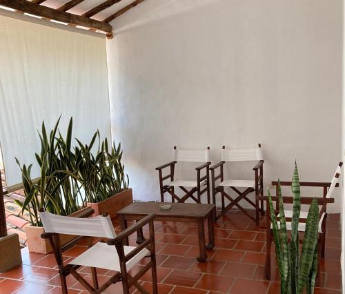 un grupo de sillas y mesas en una habitación con plantas en Casa en Barichara, en Barichara