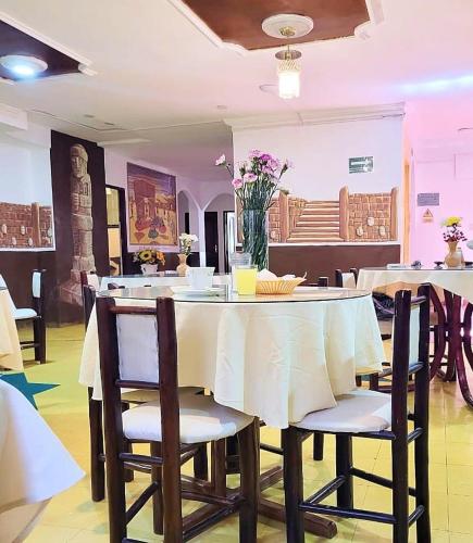 a dining room with a table with chairs and flowers at HOSTAL MAYA INN in La Paz