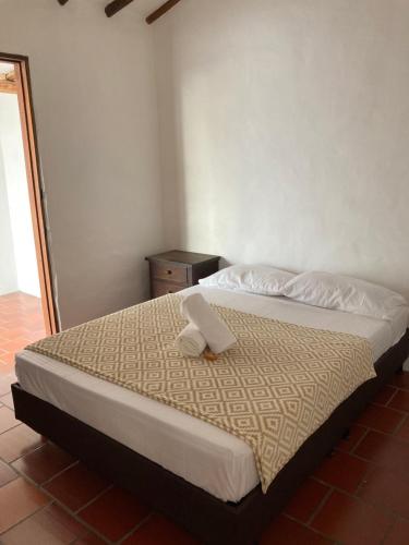 Un dormitorio con una cama con papel. en Casa en Barichara en Barichara