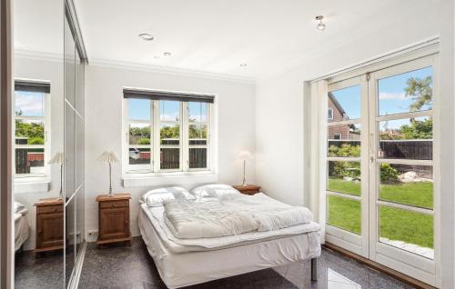 a white bedroom with a large bed and windows at Cozy Home In Skagen With Kitchen in Skagen