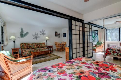 um quarto com uma cama e uma sala de estar em Hono Kai B15 em Maalaea