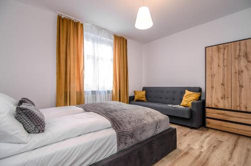 sypialnia z łóżkiem i kanapą w obiekcie Domek z trzema sypialniami - Dom Morsa Mielno w mieście Mielno