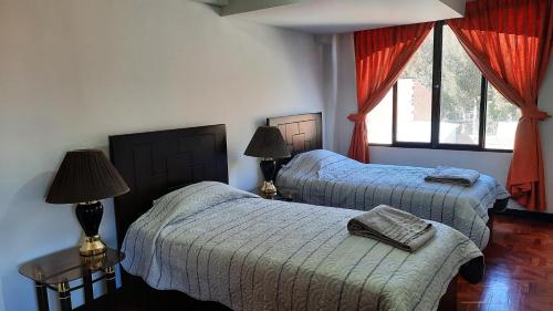 a bedroom with two beds and two windows at Apartamento acogedor independiente incluye garaje in La Paz