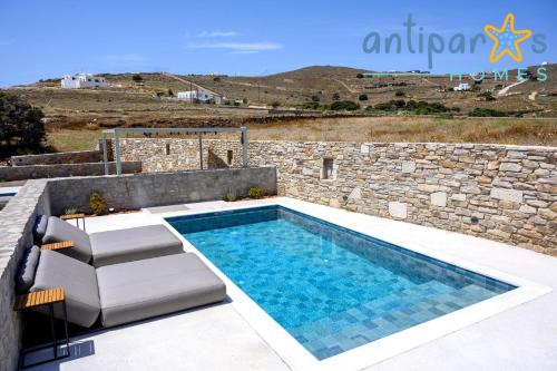 een zwembad voor een stenen muur bij Antiparos Homes in Antiparos Stad