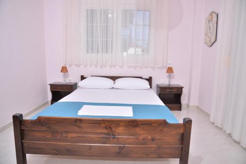 a bedroom with a large bed with two night stands at ZeusPlace Konaki House Leptokarya in Leptokaria