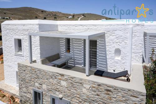 a house with a balcony with a bench on it at Antiparos Homes in Antiparos Town