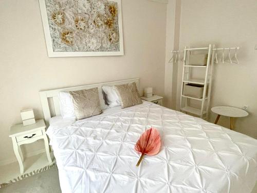 a bedroom with a white bed with a red flower on it at White House Kavala in Kavála