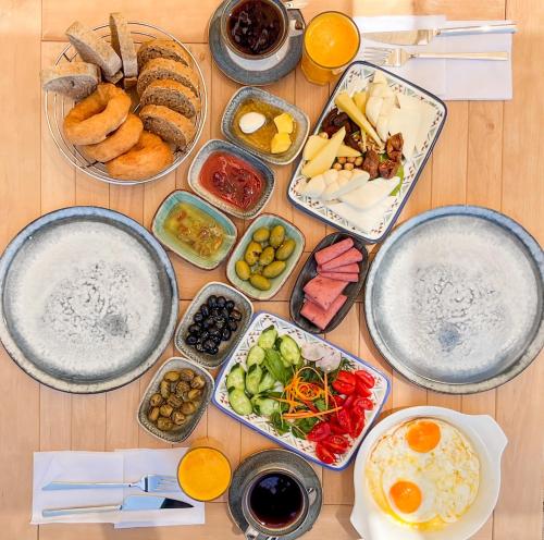 einen Tisch mit Teller mit Lebensmitteln und Schüsseln mit Lebensmitteln in der Unterkunft Thanos Hotel in Muğla