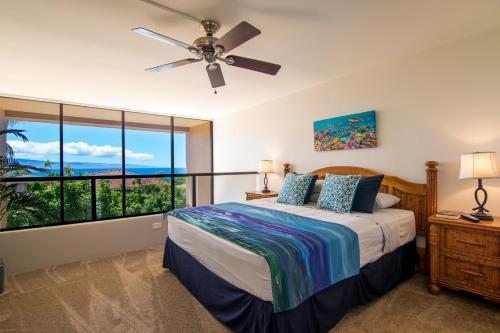 - une chambre avec un lit et un ventilateur de plafond dans l'établissement Kahana Villa E409, à Kahana