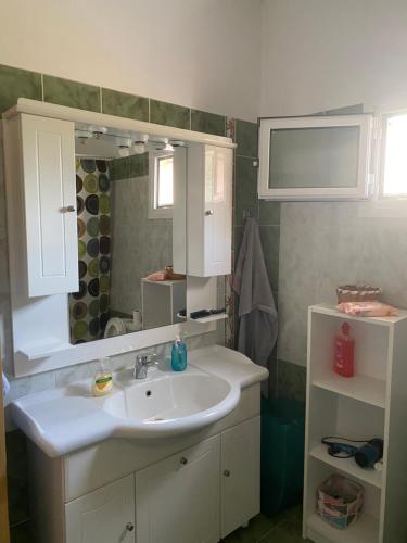 y baño con lavabo blanco y espejo. en Todos home en Amaliás