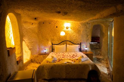 ネヴシェヒルにあるunicorn cave hotelの石造りのベッドルーム1室(ベッド1台付)