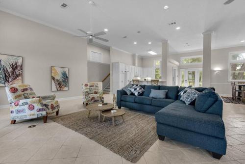 sala de estar con sofá azul y sillas en Waterfrnt, Swim-Fish, Near I10-Bchs Sunset Getaway, en Milton