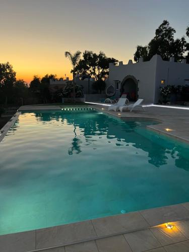 a swimming pool with a sunset in the background at Elafonisi Village in Elafonisi